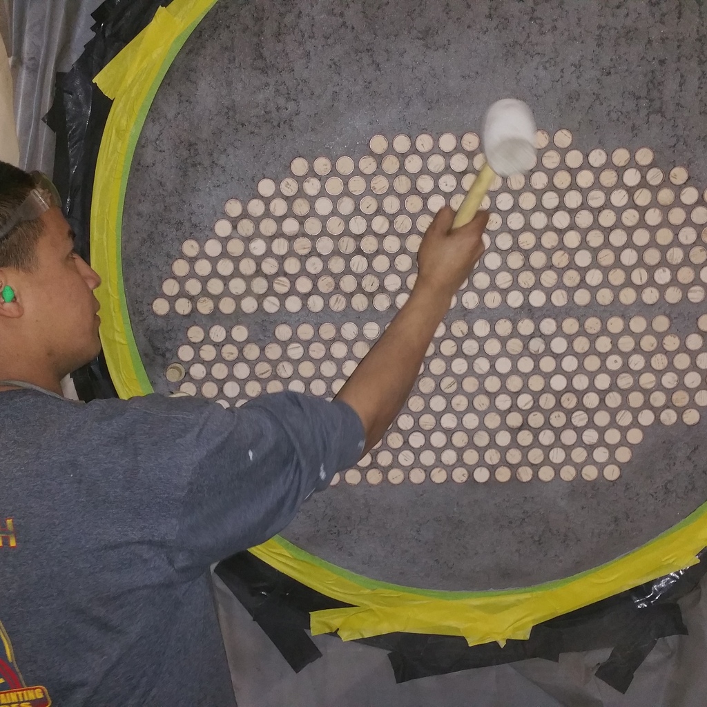A worker inserts corks into a heat exchanger head before coating with an industrial repair coating.  Industrial Coating completed by Coatech Baton Rouge. 