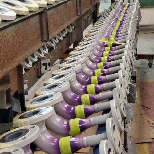Pipe fittings lined up in a row to be coated internally with a specialized repair product by Coatech Baton Rouge. 